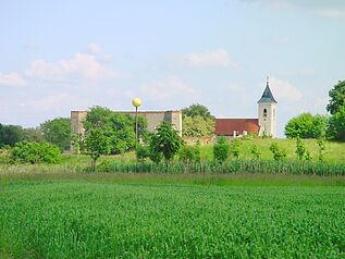 Vollmondskulptur vor Ruine und Kirche